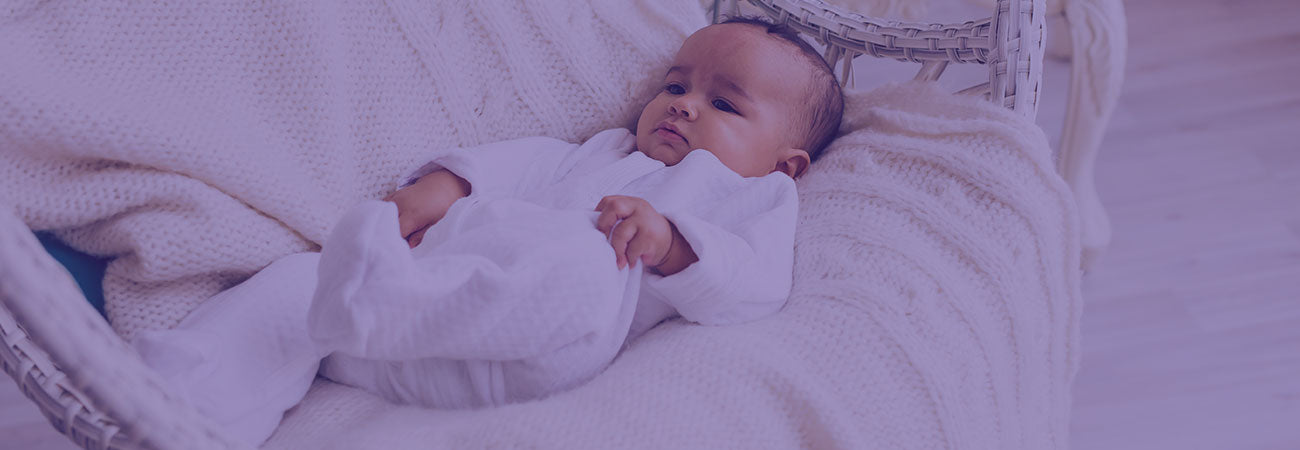 Baby in white clothes resting on chair