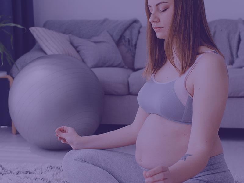 Pregnant woman doing yoga in the living room