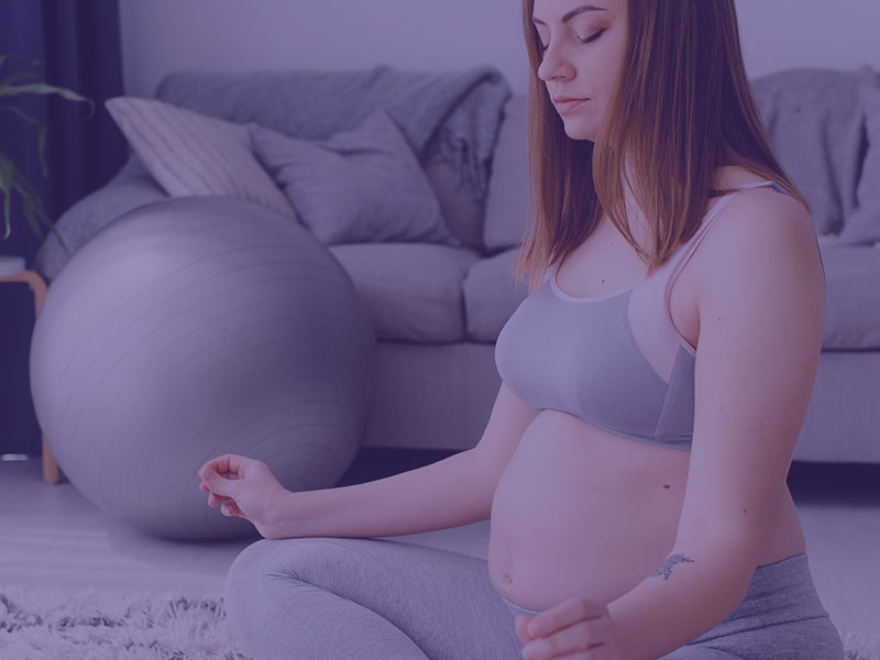 Pregnant woman doing yoga in the living room